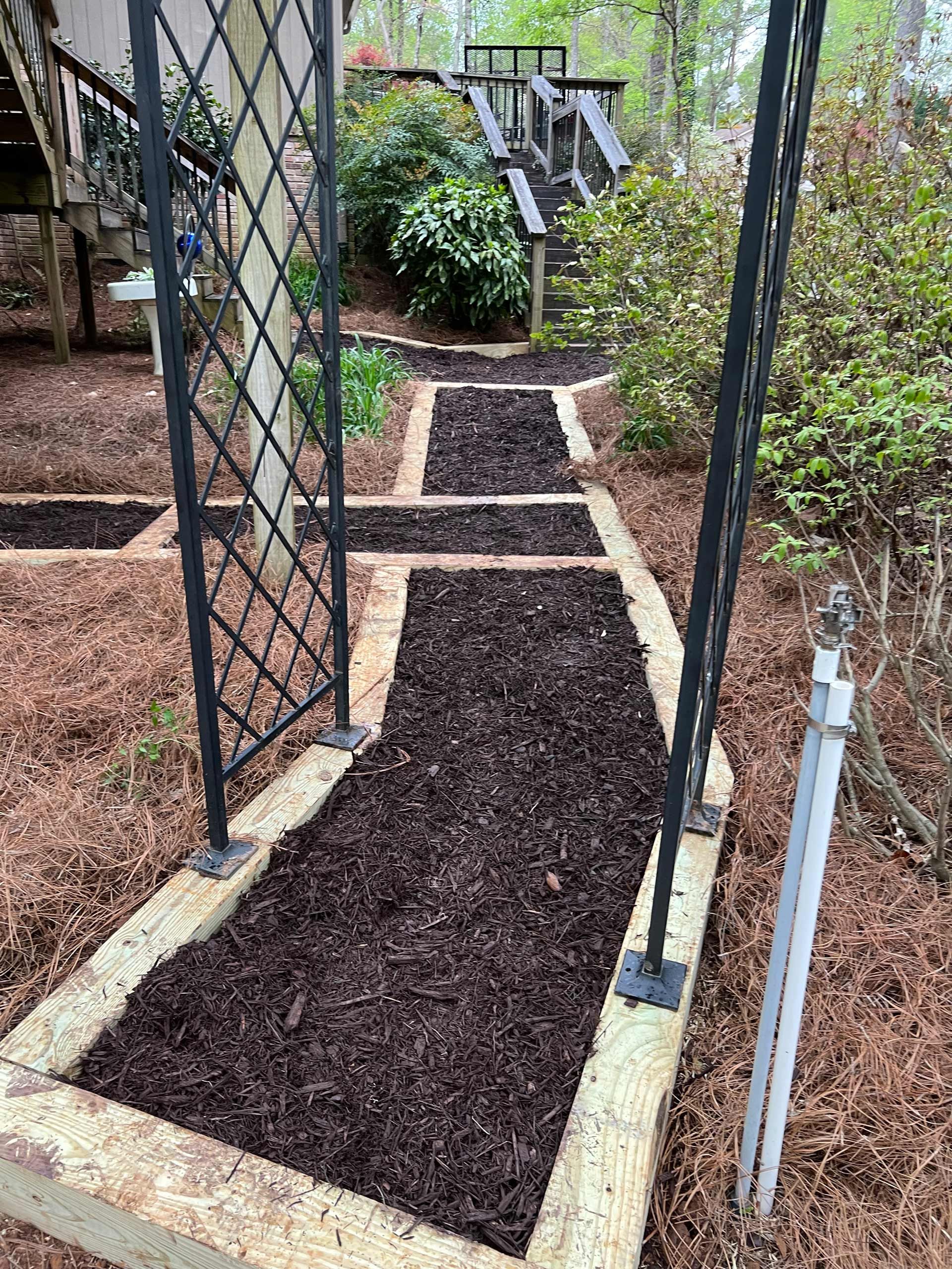 A walkway leading to a house with a fence and stairs.