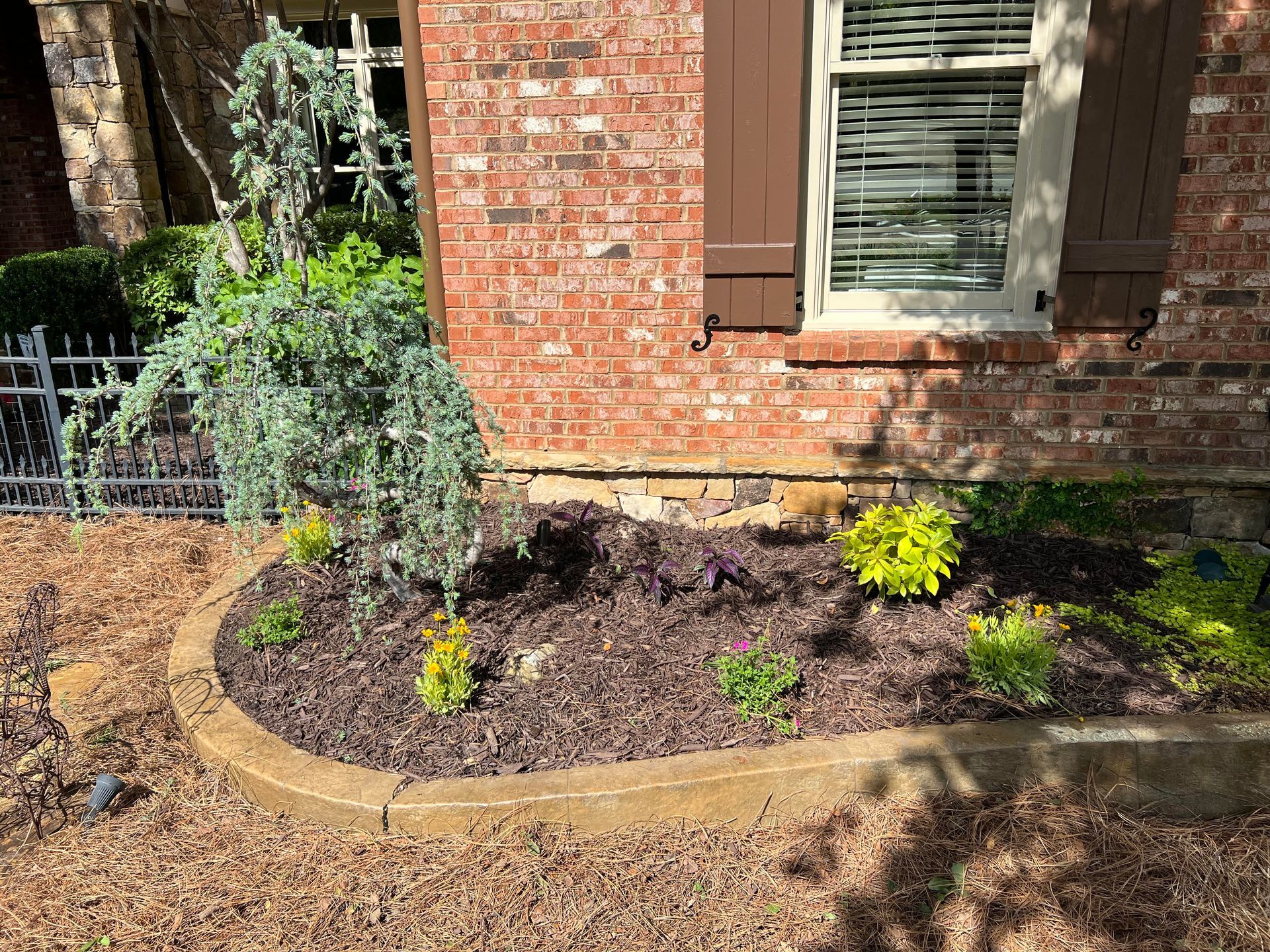 A brick house with a garden in front of it.