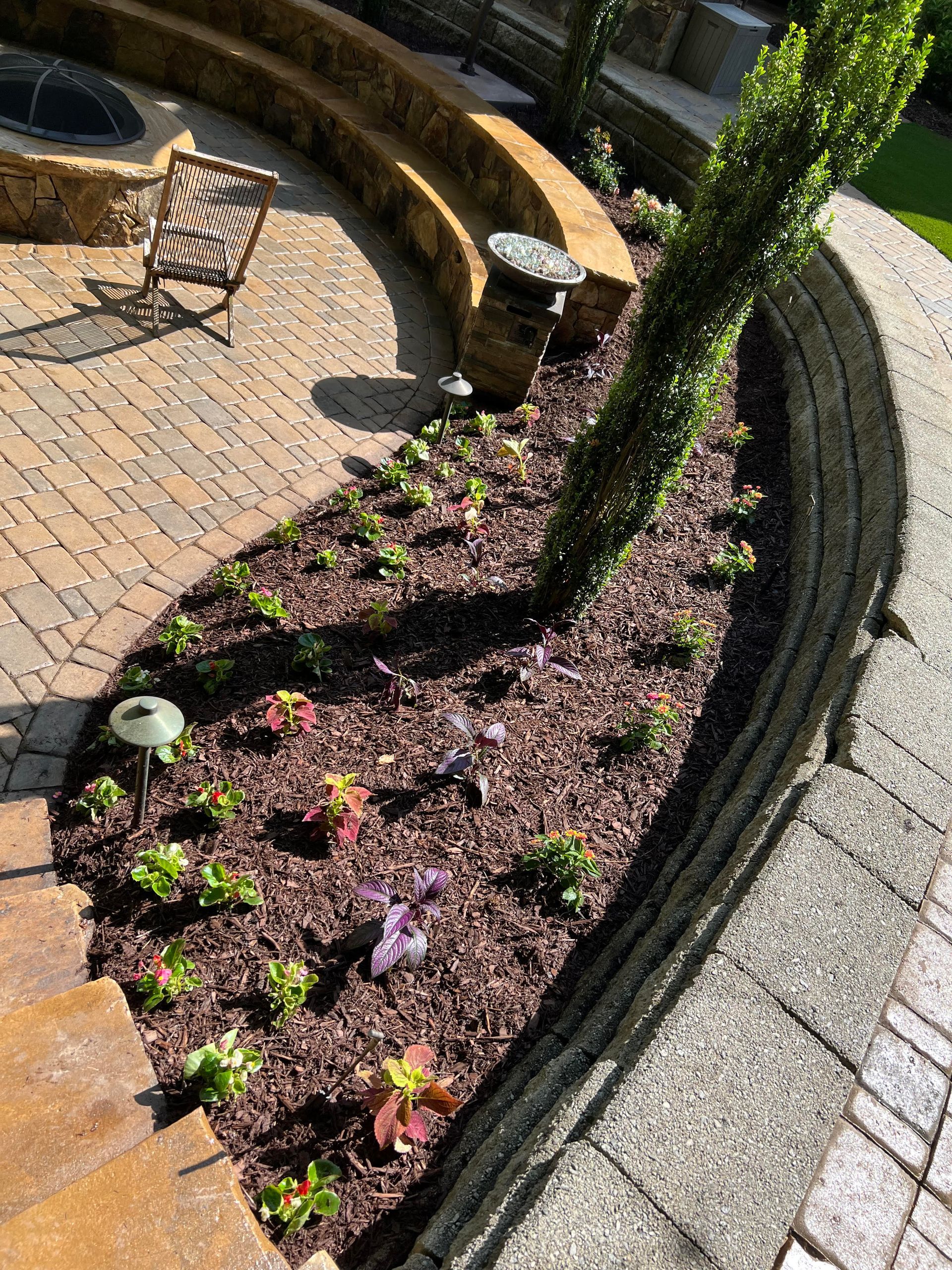 A large brick house with a stone driveway in front of it.