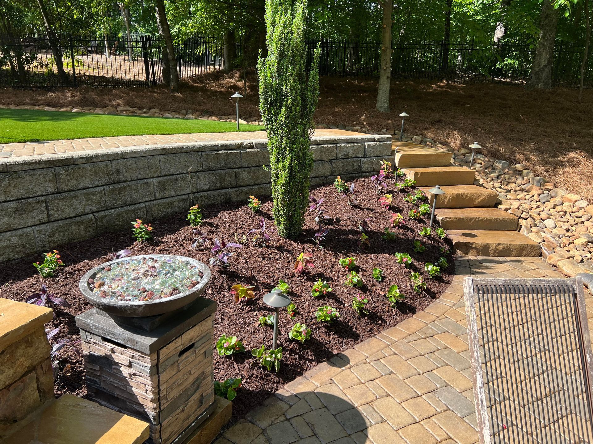There is a bird bath in the middle of the garden.