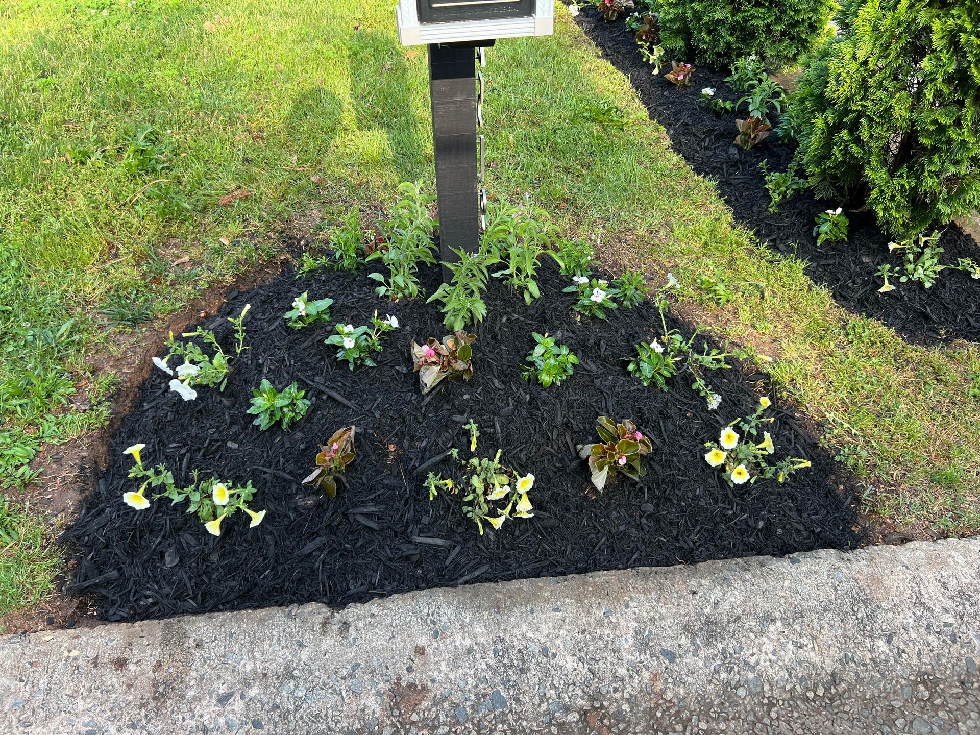 A brick walkway leading to a patio with a stone wall and a chair.