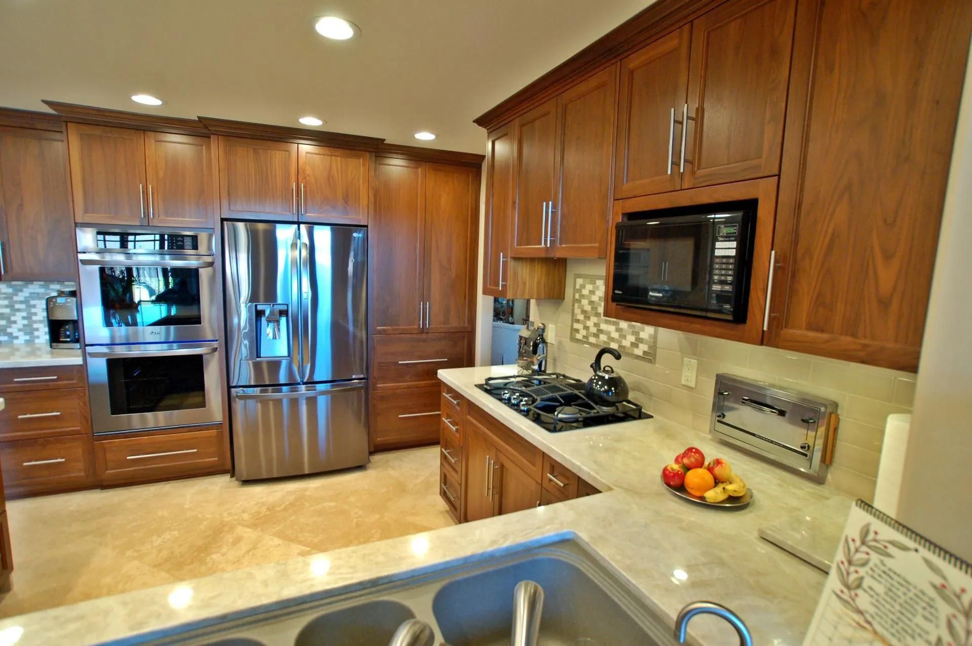 Kitchen with wooden cabinets, stainless steel appliances, and a marble countertop.