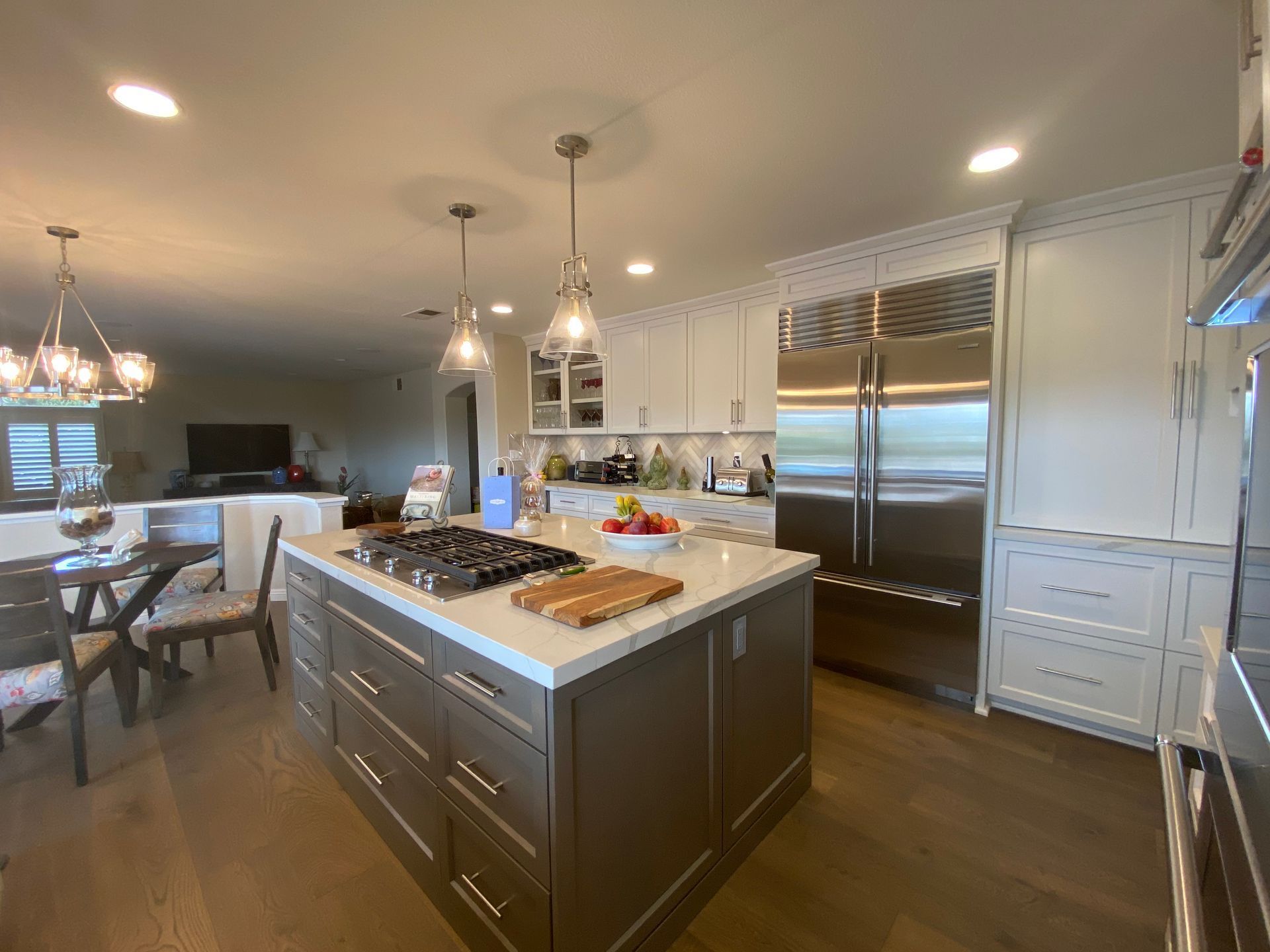 Kitchen with island, stainless steel appliances, and white and brown cabinetry.