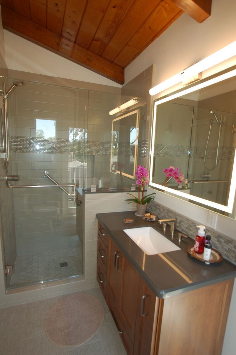 Bathroom with glass shower, wooden vanity, gray countertop, and wood-beam ceiling.