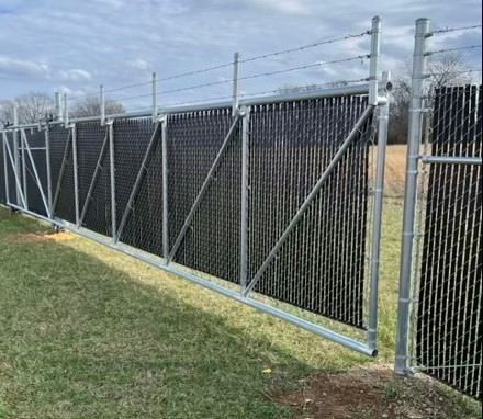 a black chain link fence with barbed wire surrounding it .