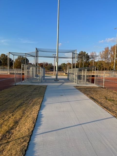 a concrete walkway leading to a baseball field