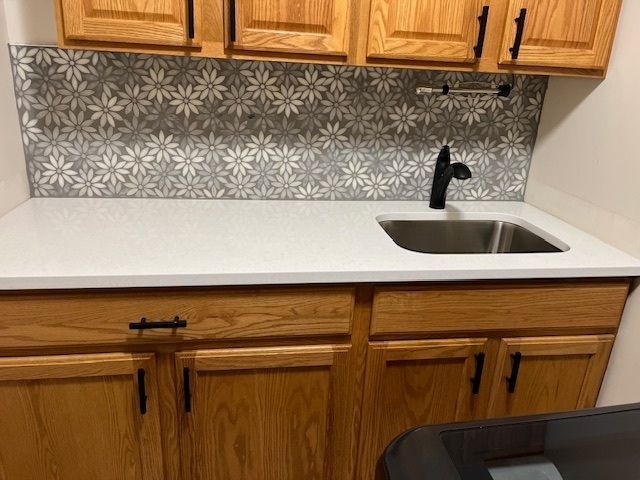 A kitchen with wooden cabinets and a stainless steel sink.