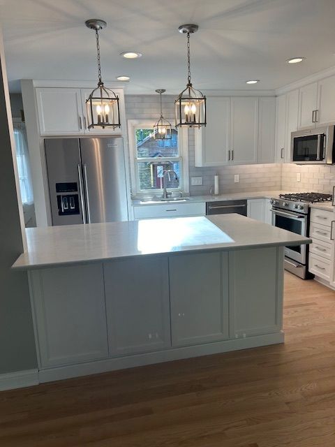 A kitchen with white cabinets and stainless steel appliances.