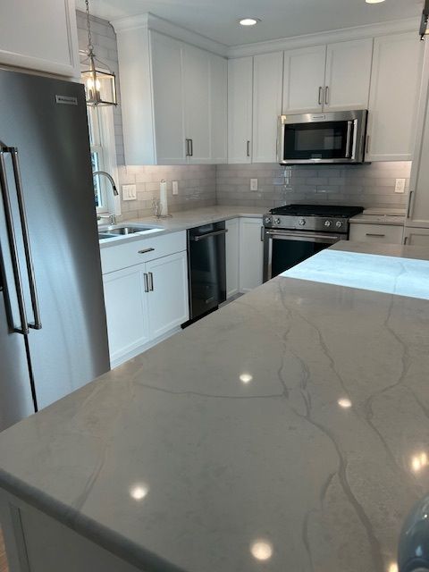 A kitchen with stainless steel appliances and white cabinets.
