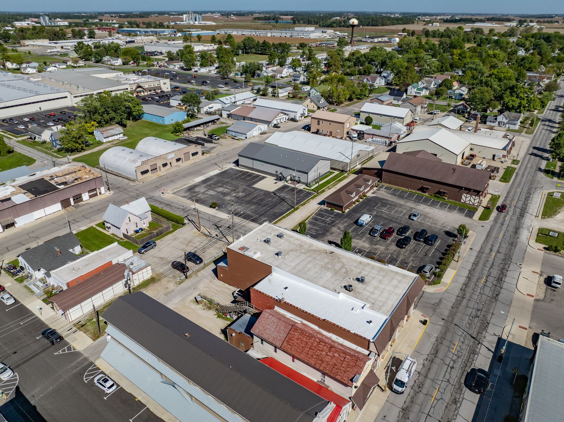 Aerial view of a small downtown with buildings, parking lots, and a main street