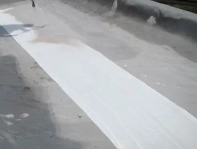 Snow-covered road with a long white strip of cleared pavement running through the center
