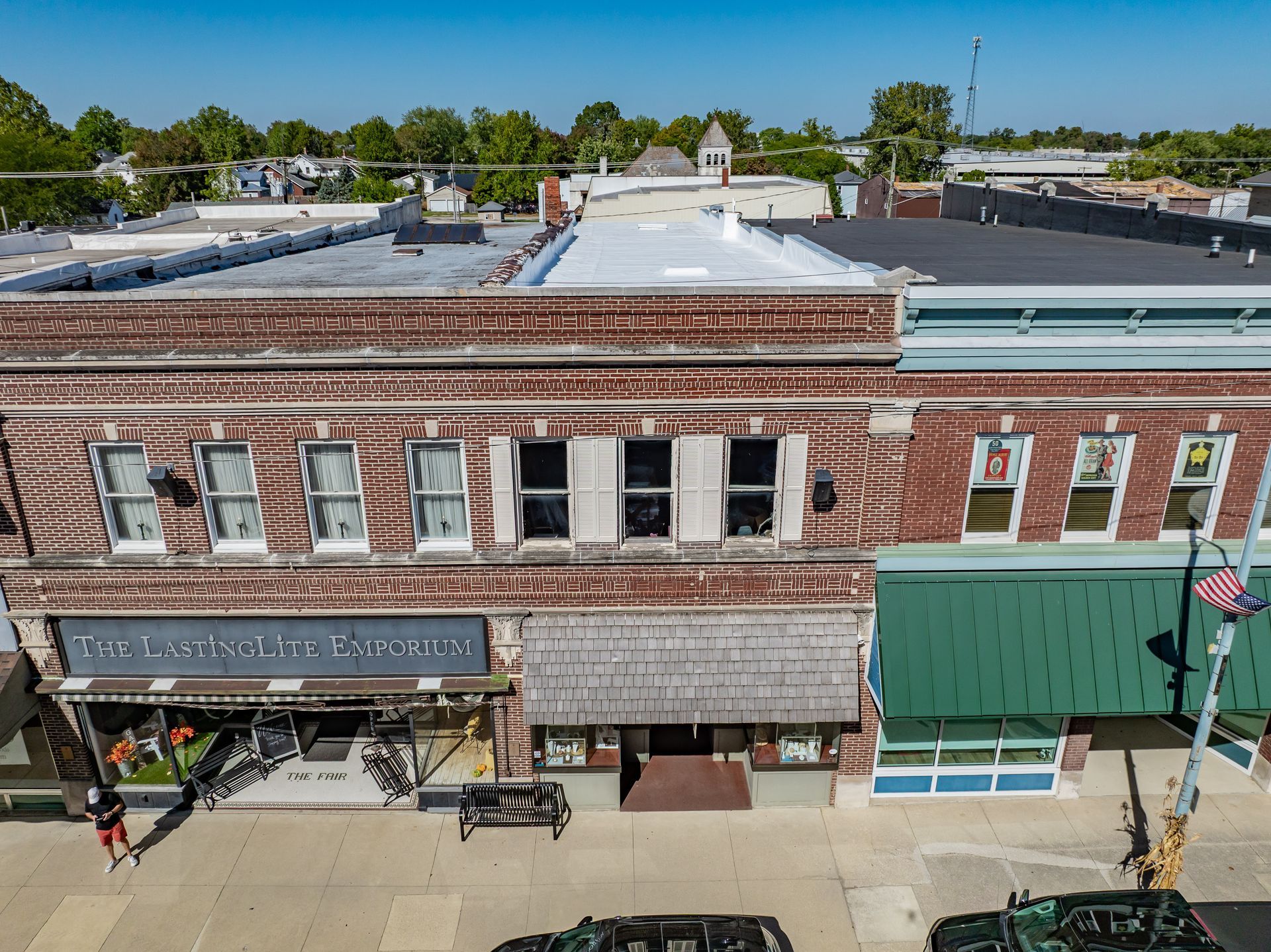 Historic brick storefronts along a downtown street with awnings and outdoor seating under a clear sky
