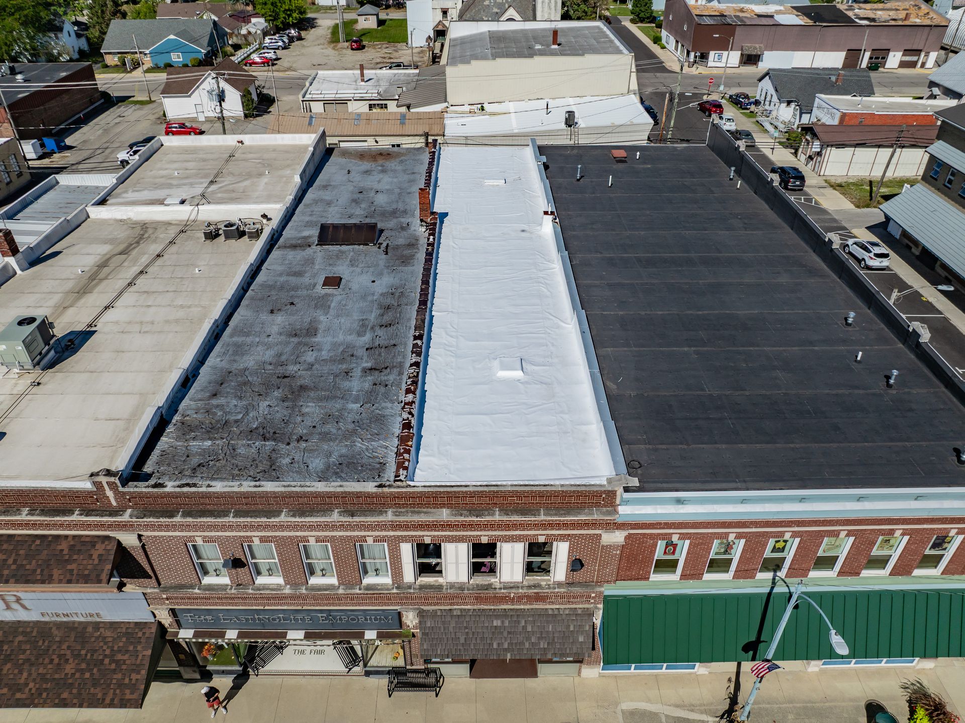 Aerial view of a row of flat-roofed brick buildings along a city street.