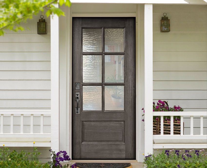 the front door of a house with two wooden doors and two windows
