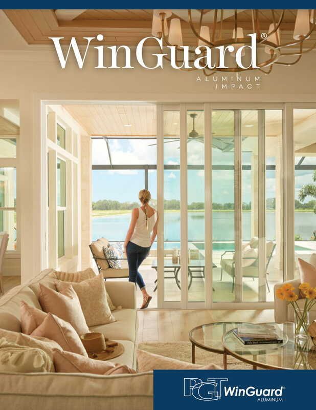 A woman is standing in a living room looking out a window.