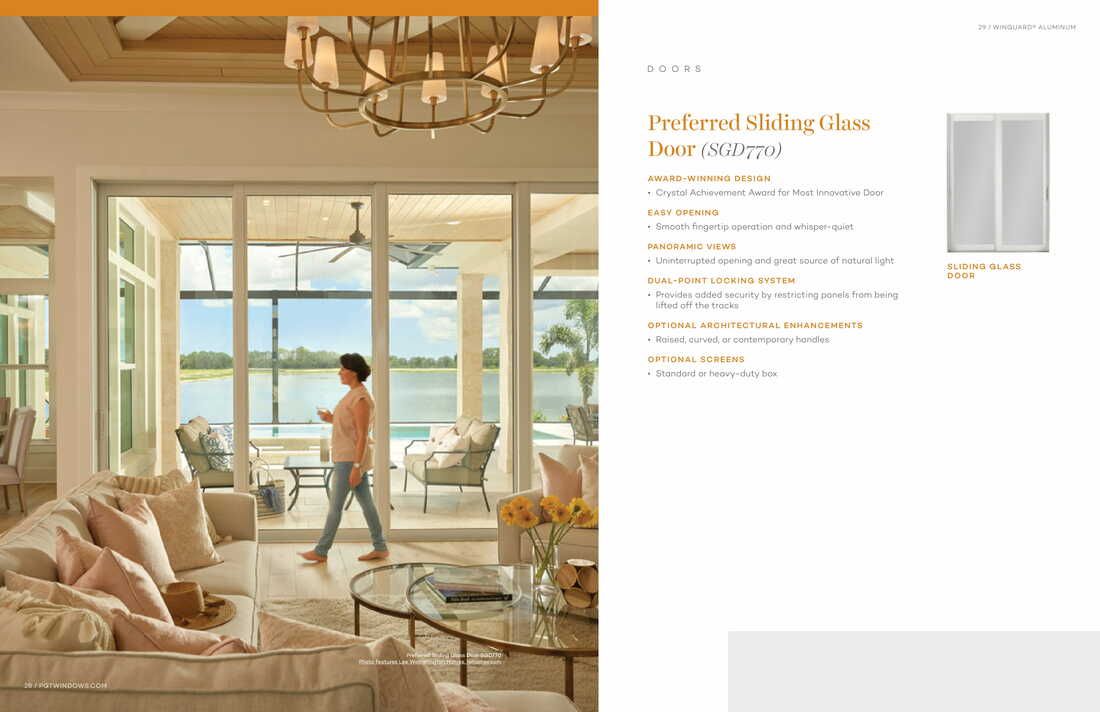 A woman is walking through a living room with sliding glass doors.