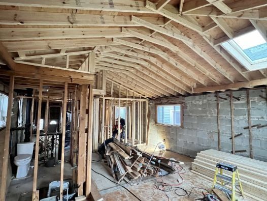 A house is being built with wooden beams and a skylight.