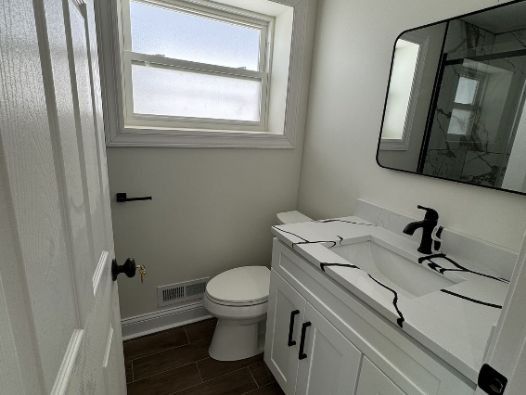 A bathroom with a toilet a sink and a mirror