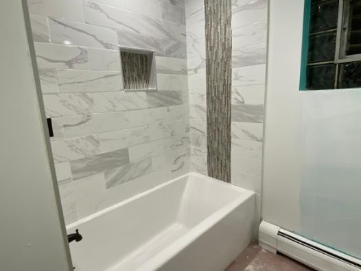 A bathroom with a bathtub and a shower stall.