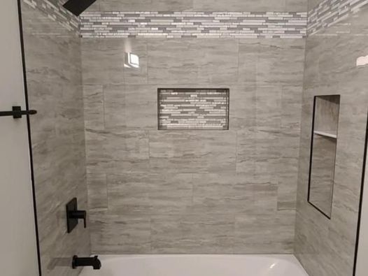 A bathroom with a bathtub and a shower.