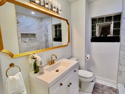 A bathroom with a sink , toilet and mirror