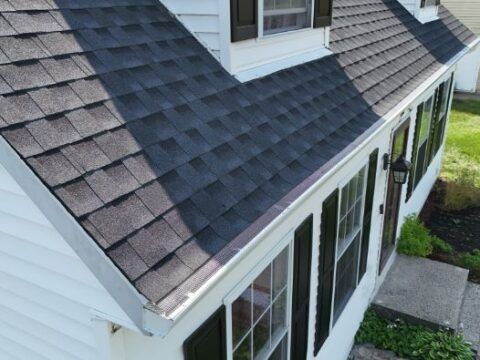 A white house with a black roof and black shutters