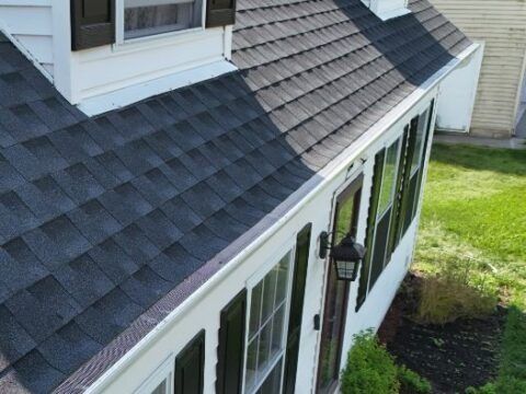 A white house with a black roof and black shutters