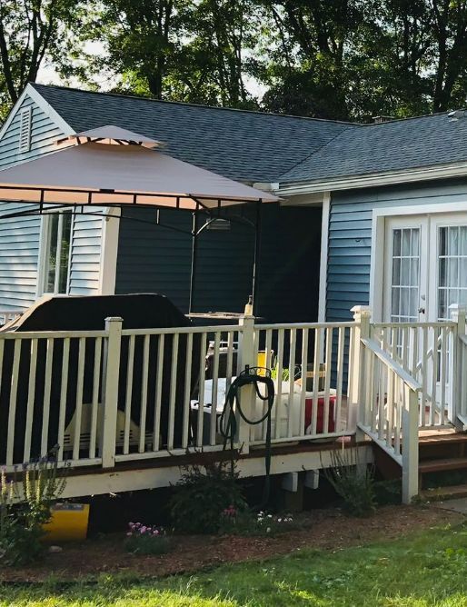 A house with a deck and umbrella in front of it