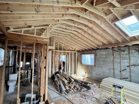 A house is being built with wooden beams and a skylight.