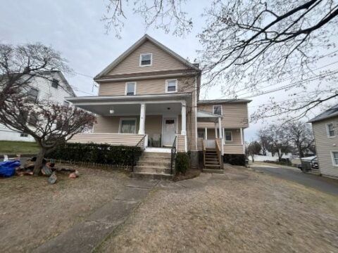 A large house with a porch and stairs is for sale.