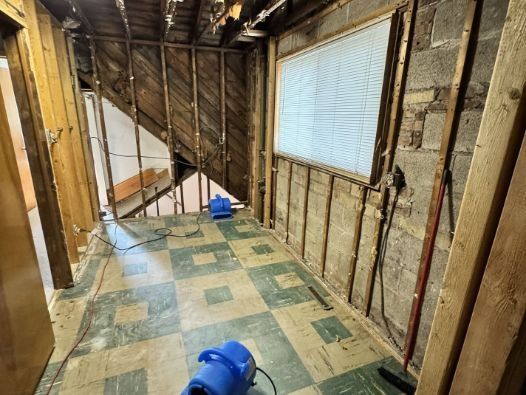 A hallway with a blue vacuum cleaner in the middle of it.