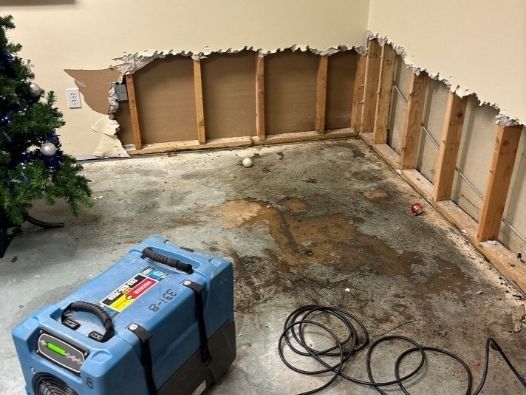 A blue machine is sitting in a room with a christmas tree in the background.