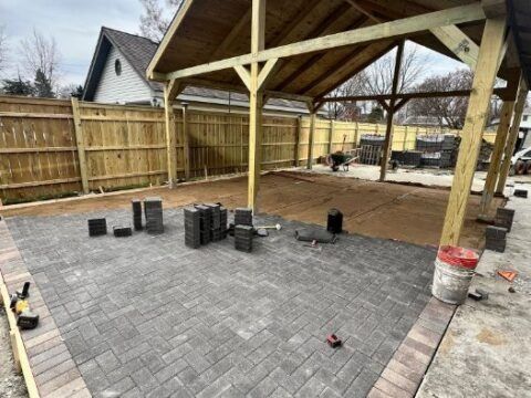 A wooden pavilion is being built in a backyard.