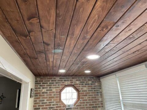 A room with a wooden ceiling and a brick wall.