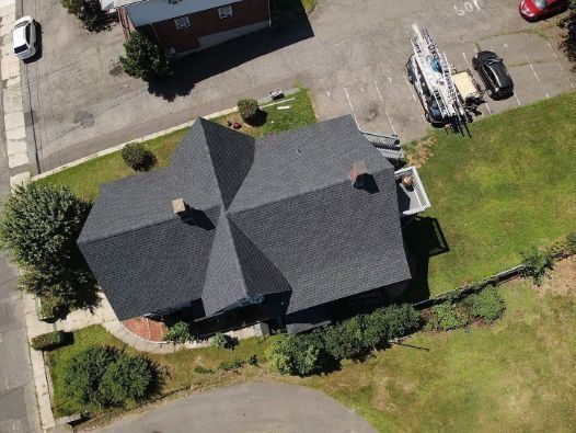 An aerial view of a house with a roof that is being repaired.