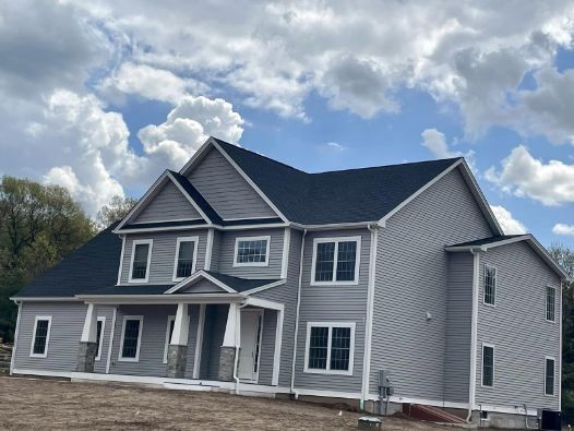 A large gray house with a black roof and white trim
