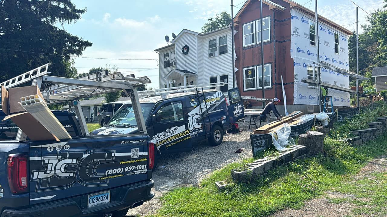A couple of trucks parked in front of a house.