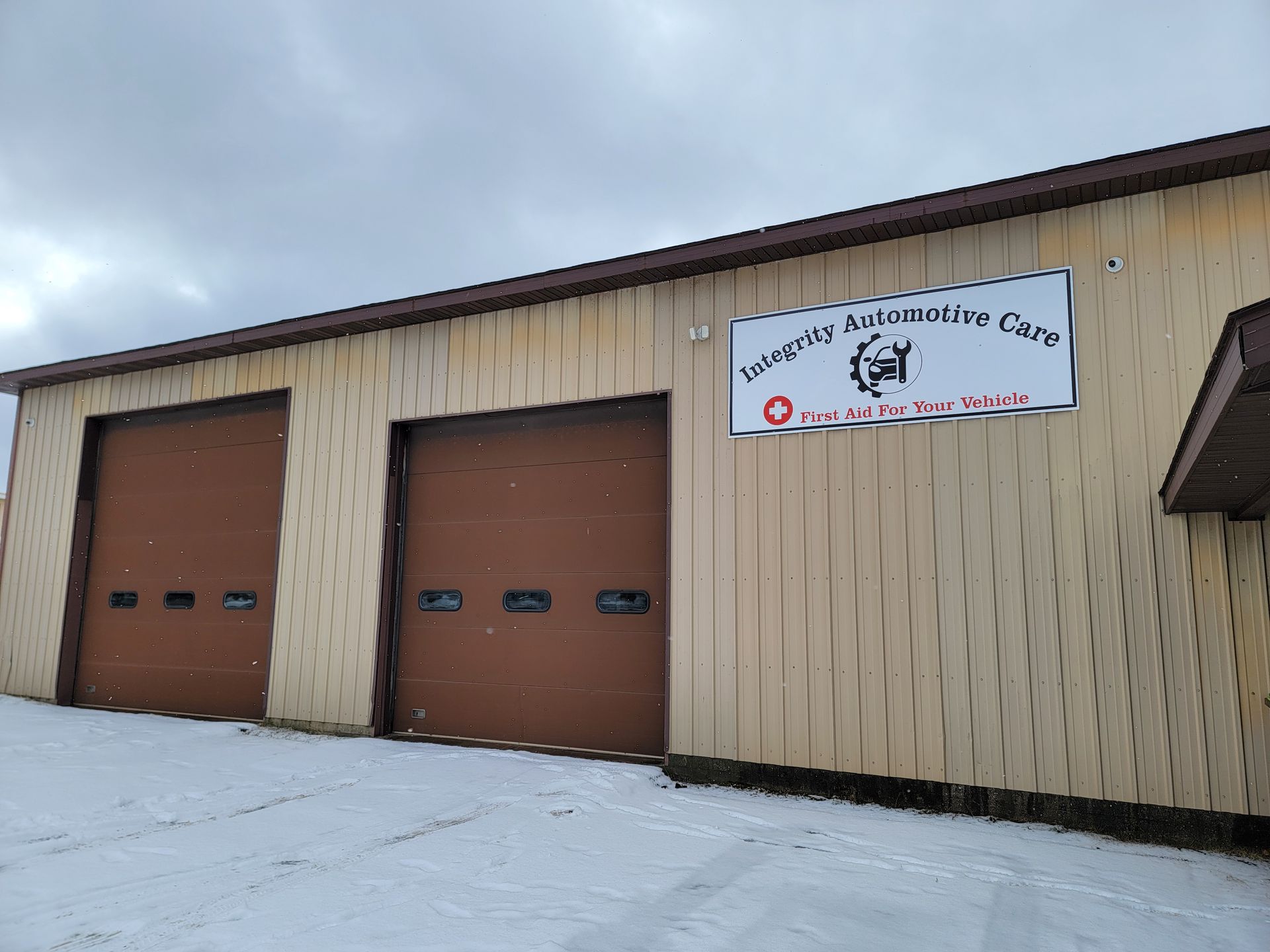 A large building with brown garage doors and a sign on the side.