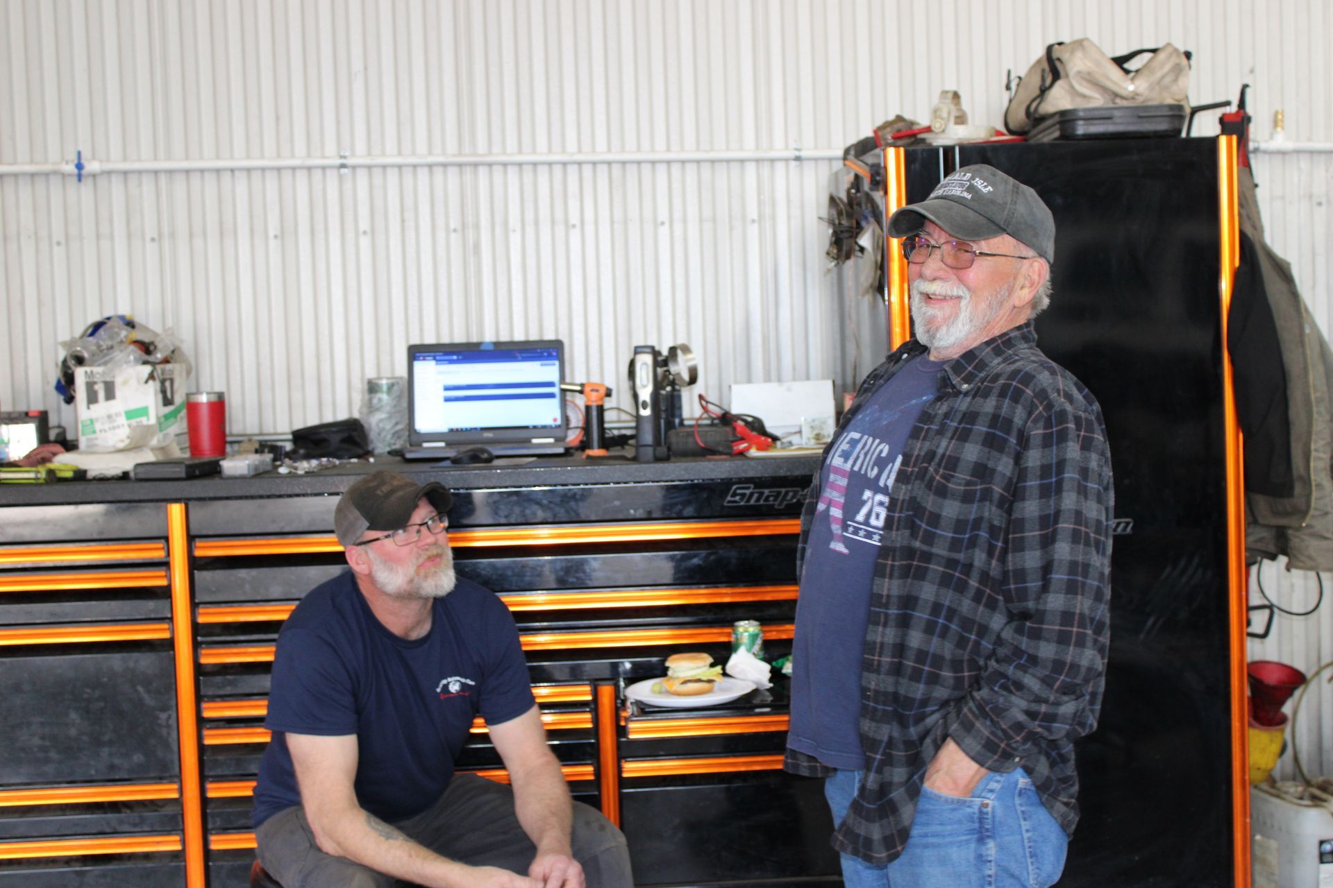 Two men are standing next to each other in a garage.