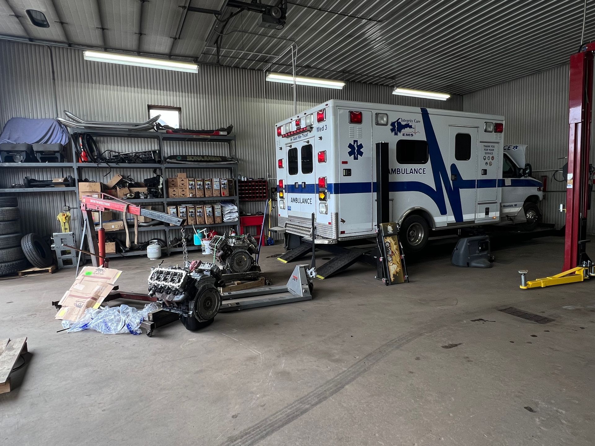 An ambulance is sitting on a lift in a garage.
