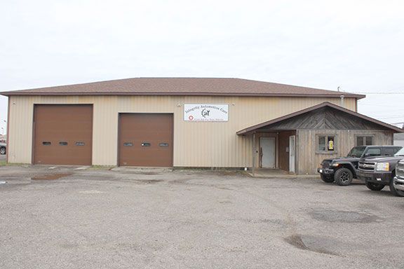 Two trucks are parked in front of a large building.
