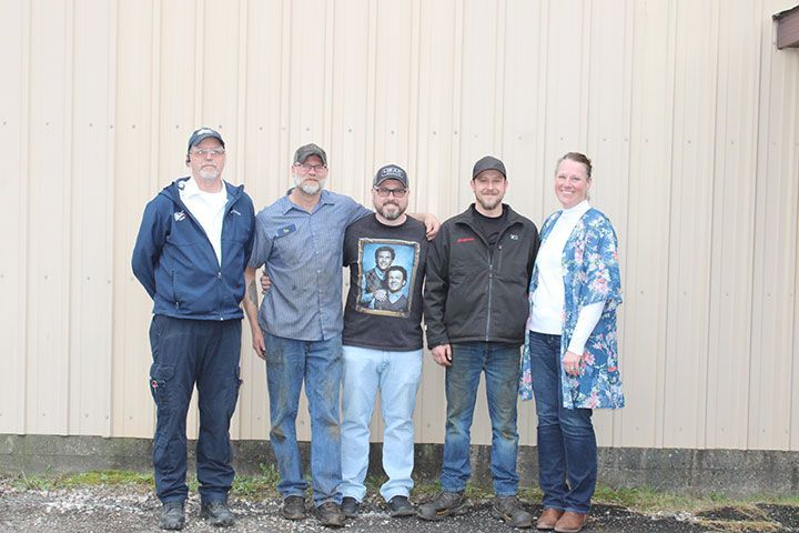 A group of people are posing for a picture in front of a building.