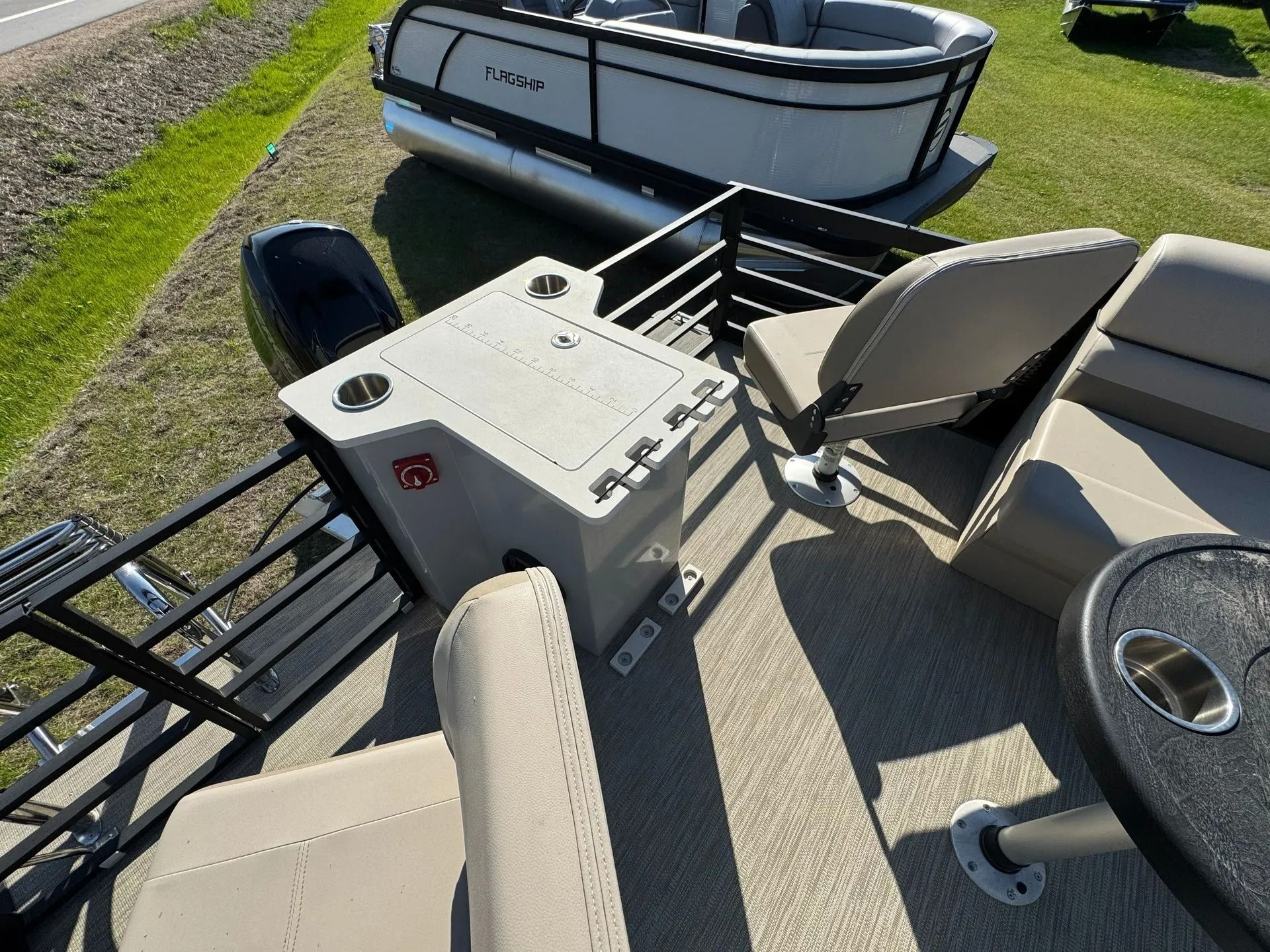 Damaged golf cart overturned on pavement beside a small boat and grass field.