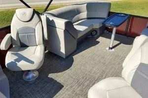 Luxury boat cabin with white captain’s chairs, gray seating, and a small blue-topped table