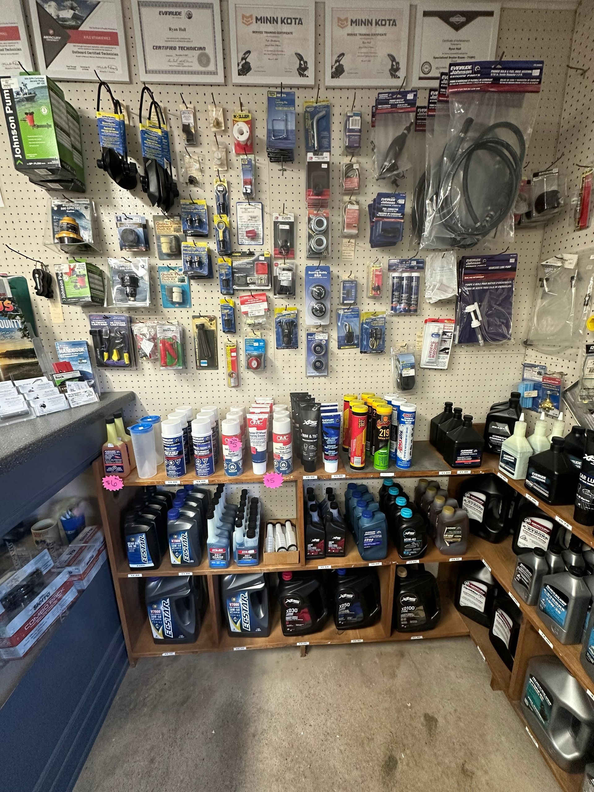 Wall of auto parts and accessories displayed on shelves and hooks in a small shop.