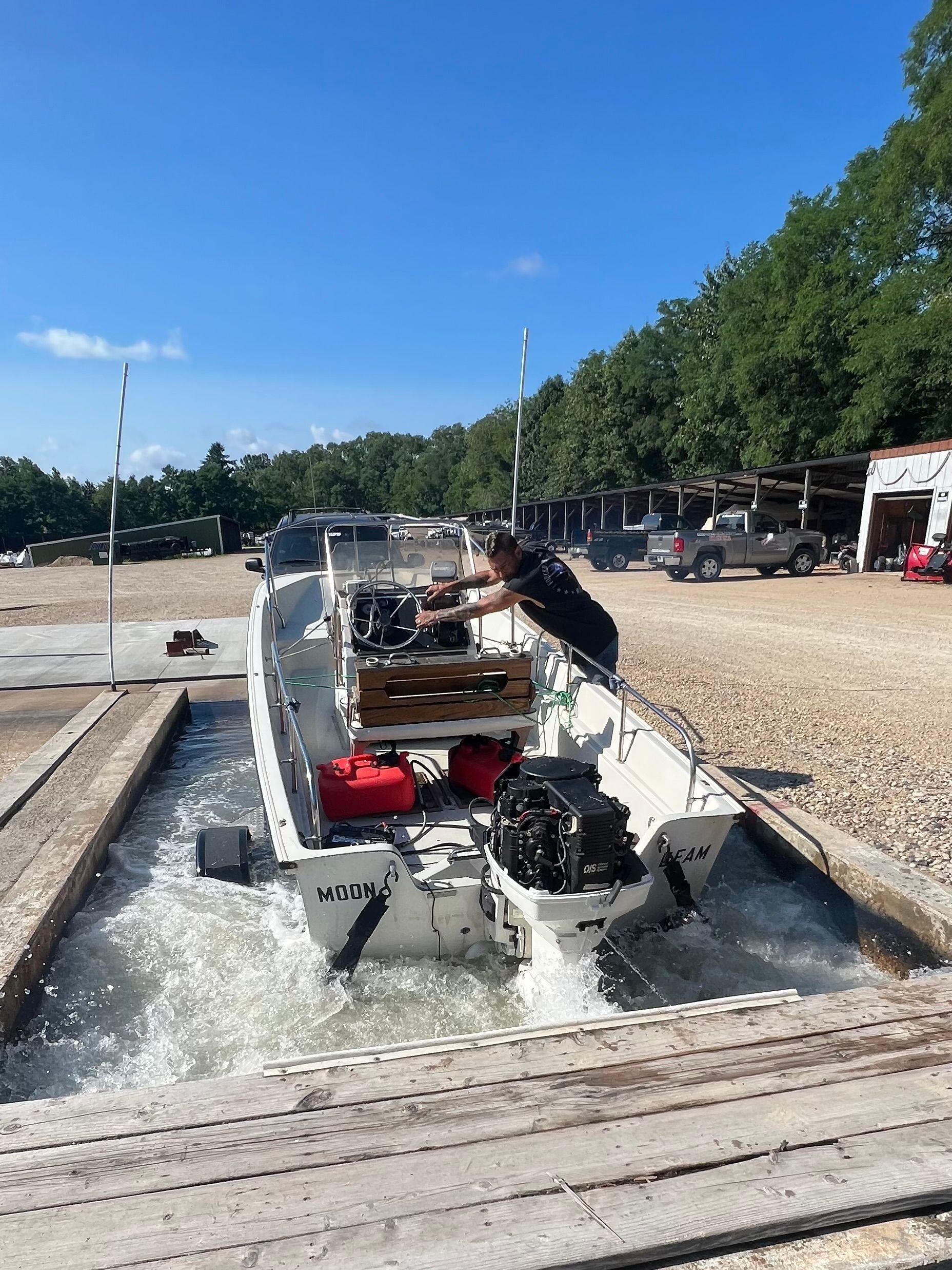 Person driving an off-road vehicle through a shallow water obstacle on a sunny outdoor track