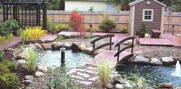 Backyard garden with pond, bridges, shed, and various plants. Brown and green colors.