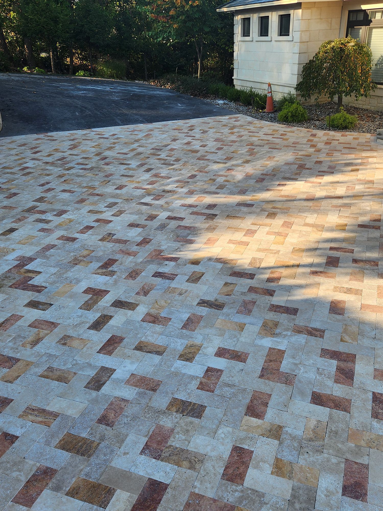 Brick driveway in a basketweave pattern, with a building in the background.