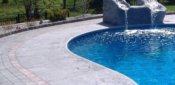 Pool with water feature and paved surround.