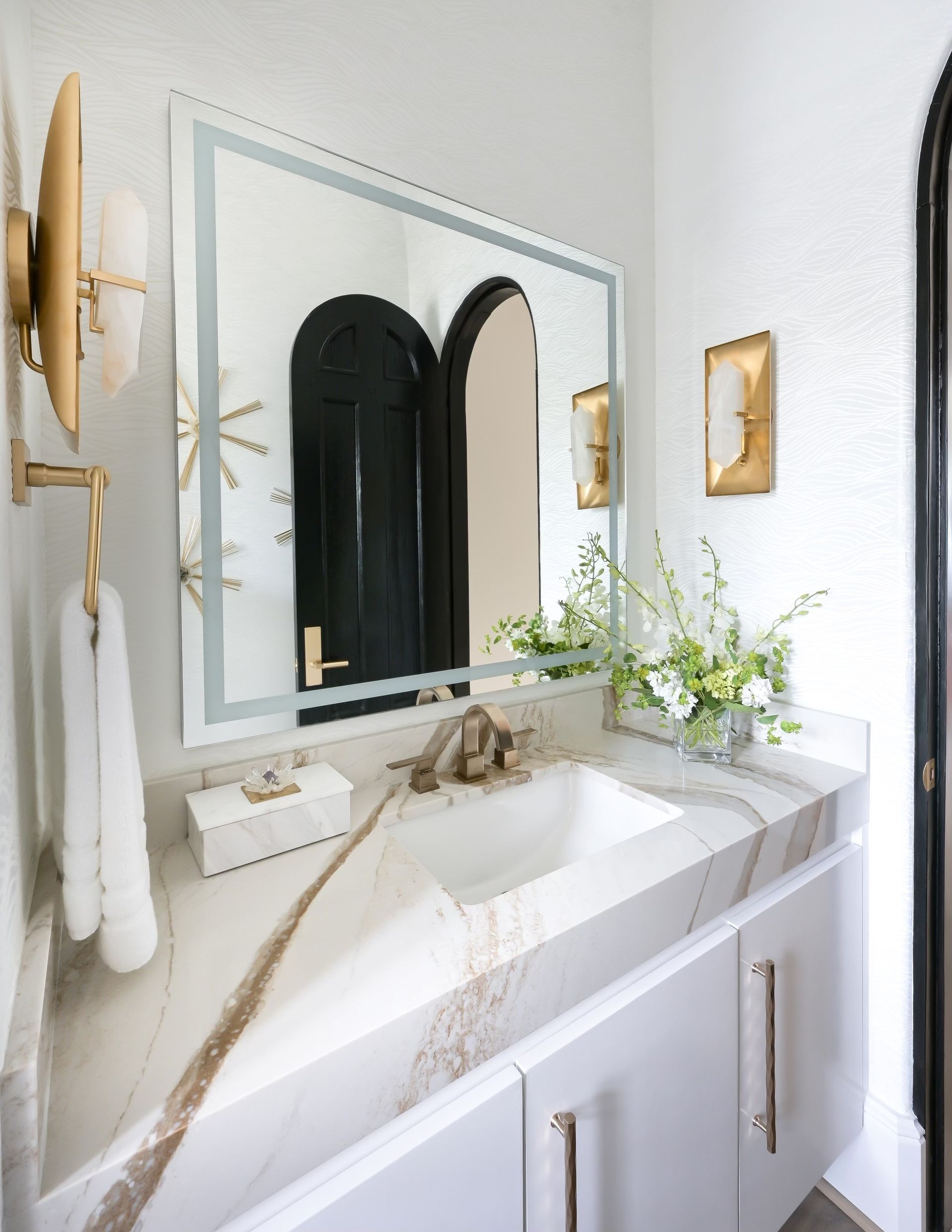 A white farmhouse sink is in a kitchen next to a window.